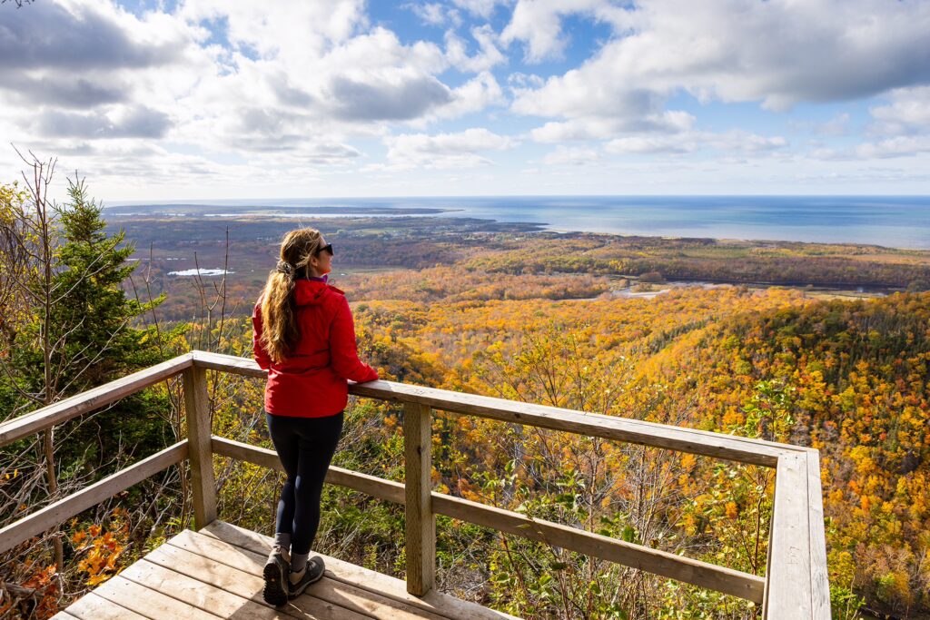 A hiker enjoys the view from a viewing platform on the Acadian Trail in the Cape Breton Highlands National Park.