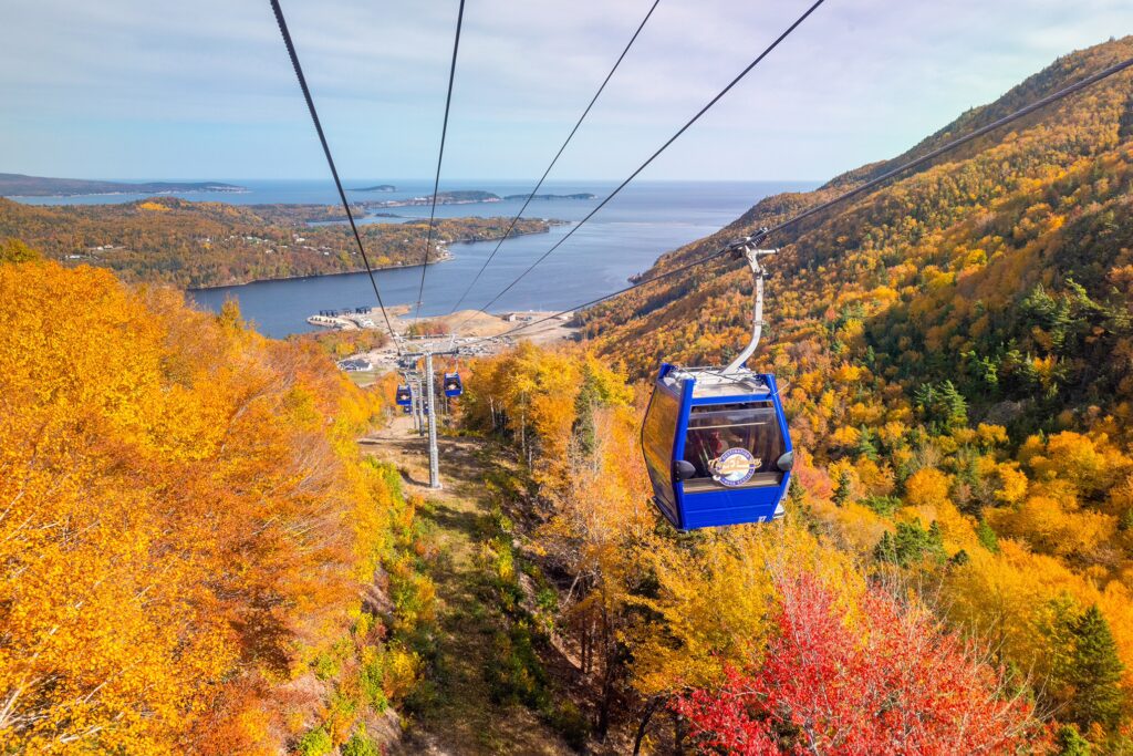Cape Smokey gondola with fall foliage and the Atlantic Ocean in the background