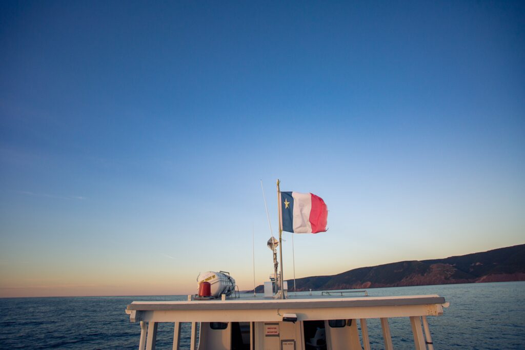 a Whale watching boat with an Acadian flag flying in the wind