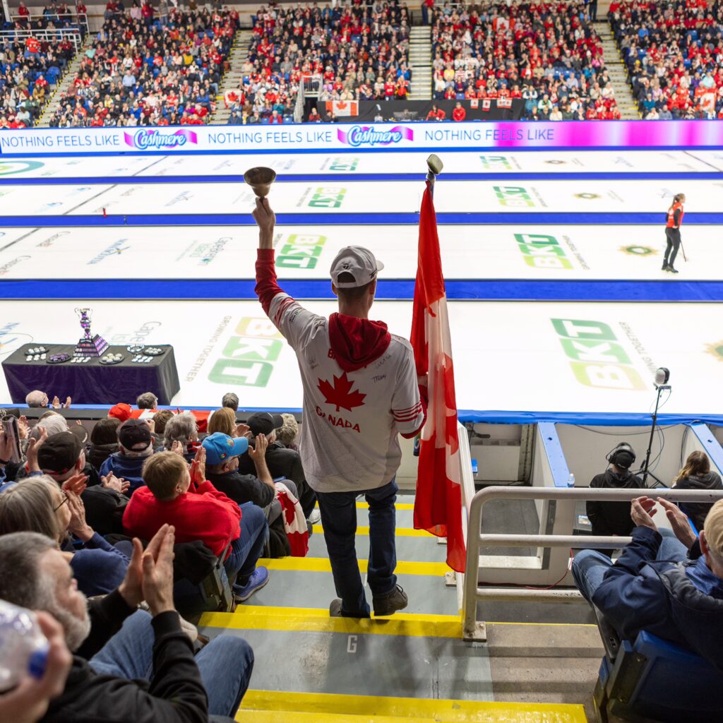 a fan cheers on curlers