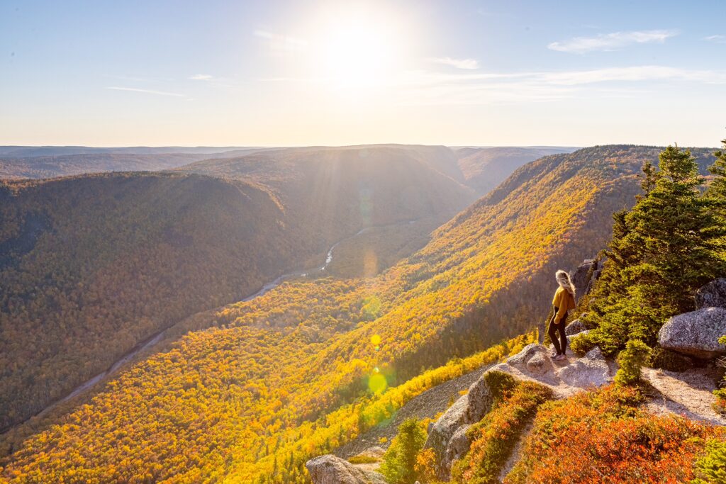 A hiker on Franey Trail in the cape breton highlands national park in autumn foliage