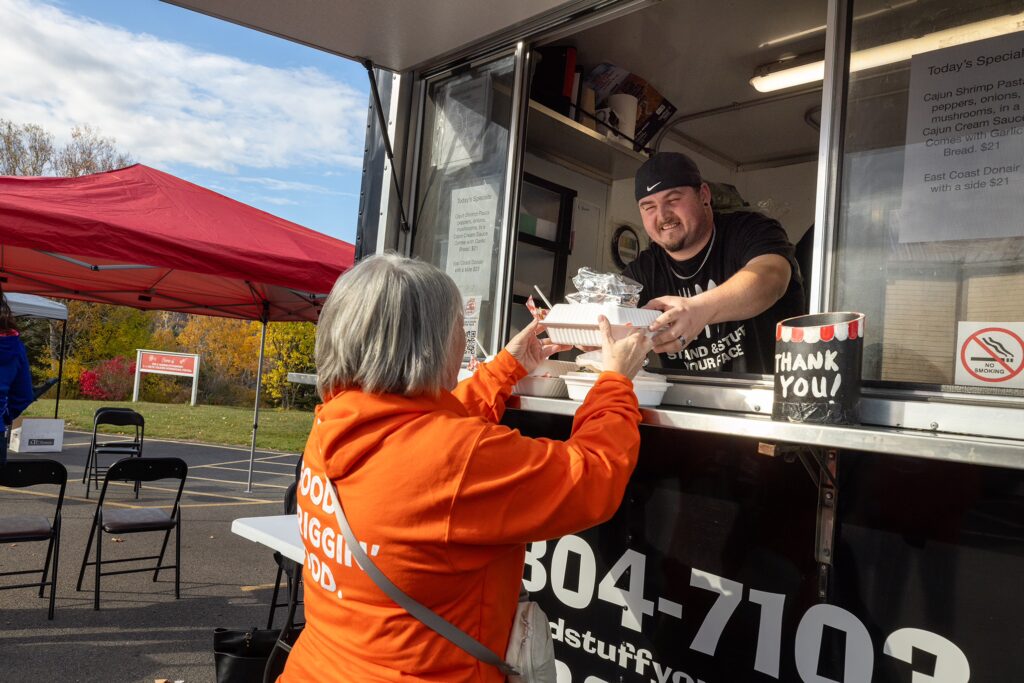 a patron receives a food order at the cabot trail trail food truck rally