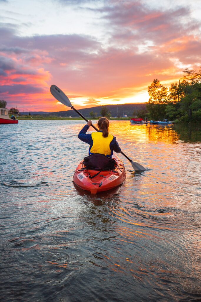 a kayayer paddling on a lake