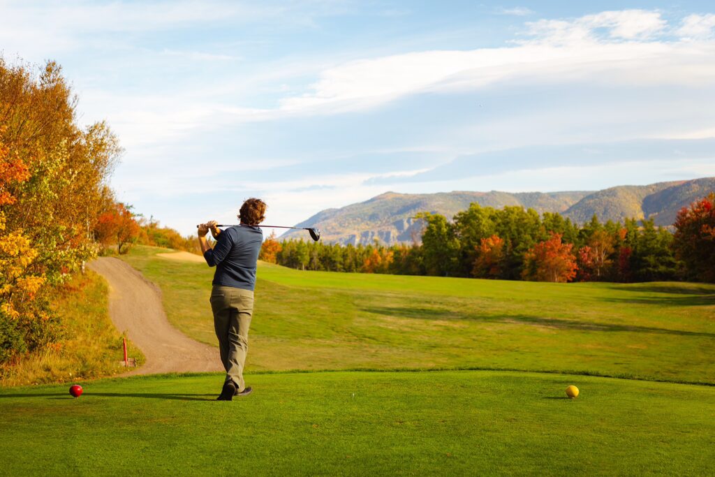 A golfer hits a ball at La portage golf course in Chéticamp
