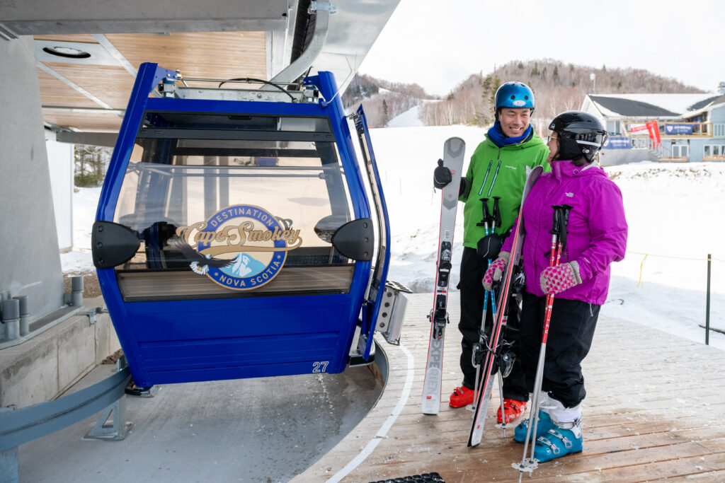 Two people await to board the gondola at cape smokey